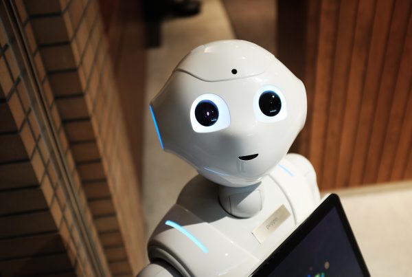 A photo of a cute robot with an appearance of a smile and large eyes gazing up at the camera.