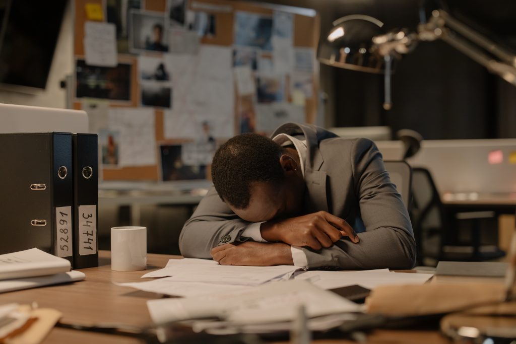 A photo of a worker napping at their desk. What employers should know about fatigue is that the solutions to reducing fatigue can be as simple as giving workers permission to take a short nap during their shift.